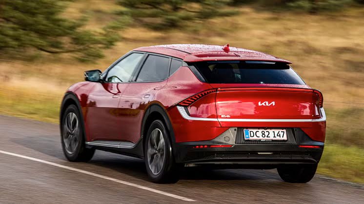 En hvid Kia EV6 elbil parkeret udendørs.