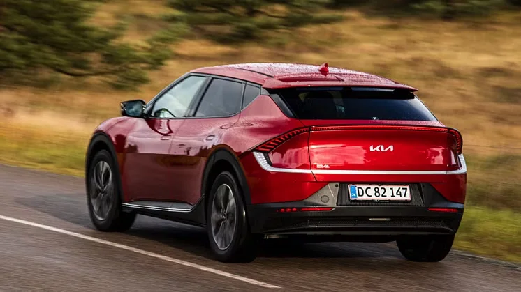En hvid Kia EV6 elbil parkeret udendørs.