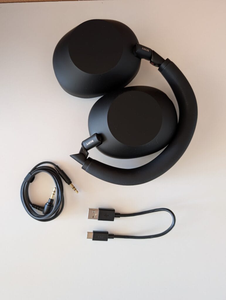 XM6 og det medfølgende tilbehør, bestående af et lydkabel samt et kort USB-c kabel.