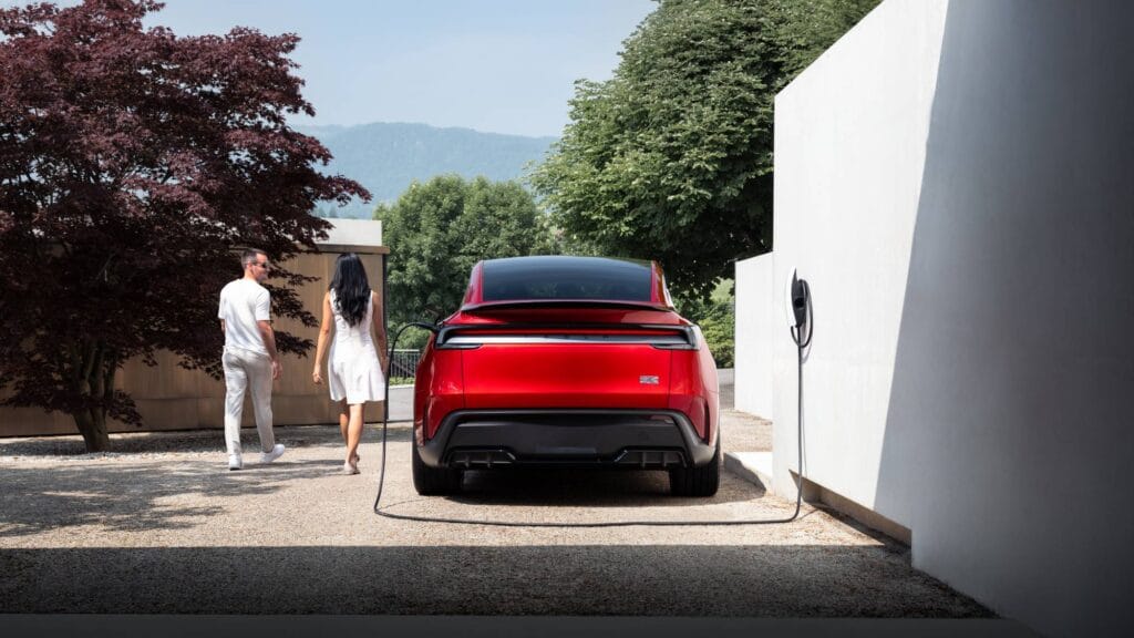  to personer ved eb Tesla Model Y i en indkørsel