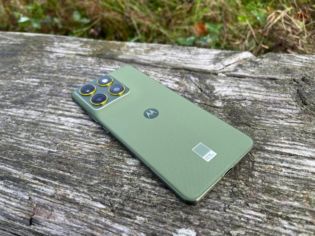 Motorola Edge 70 bagside i grøn Pantone farve holdt i hånden.