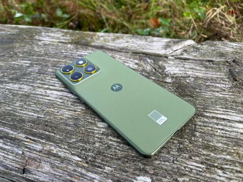 Motorola Edge 70 bagside i grøn Pantone farve holdt i hånden.