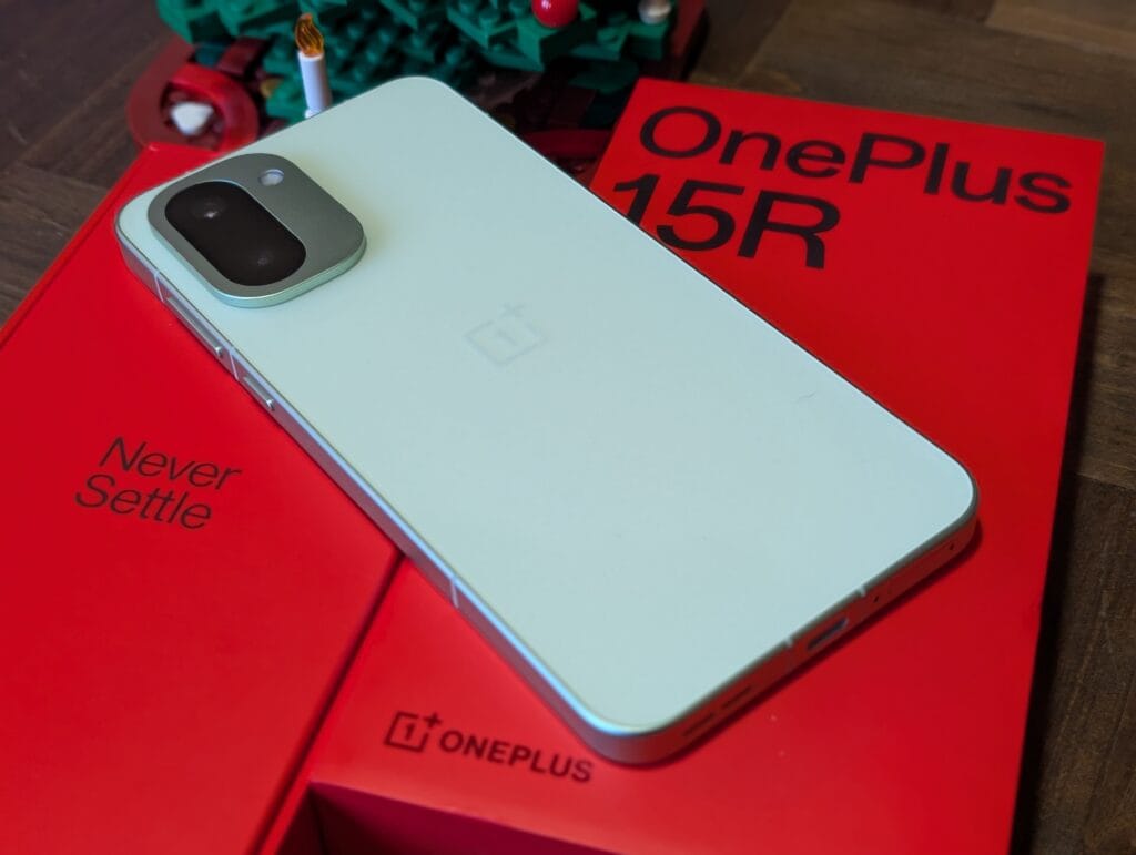 OnePlus 15R test og anmeldelse - smartphone i mørk farve ved siden af salgsæsken