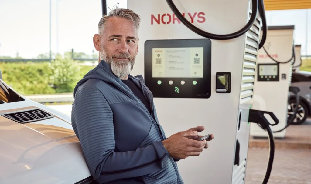 Elbilist lader sin bil op ved en ladestander fra Norlys