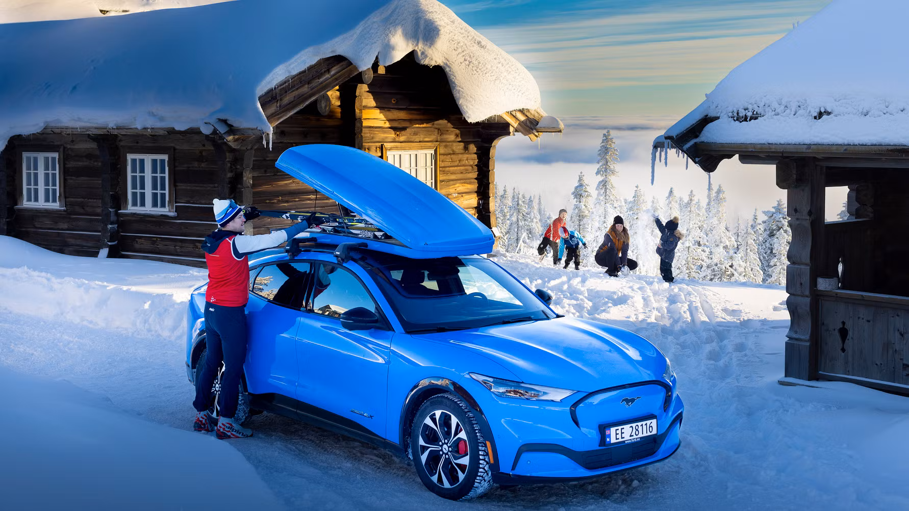 Blå Ford Mustang Mach-E elbil der kører på en vej i vintervejr.